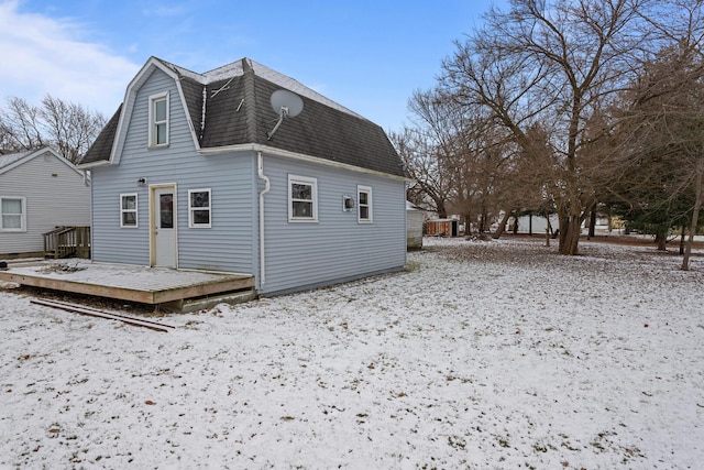 snow covered house with a deck