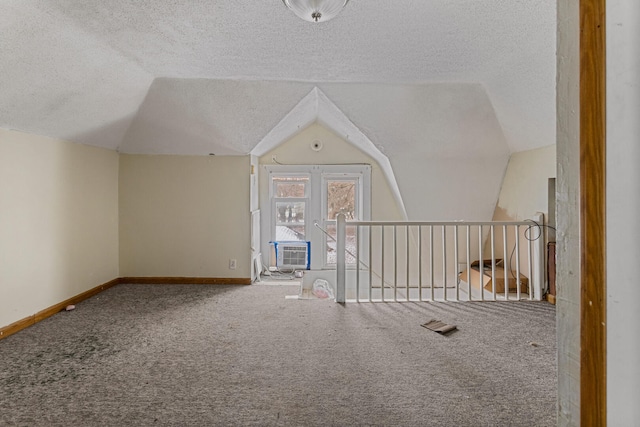 bonus room featuring a textured ceiling, carpet floors, cooling unit, and vaulted ceiling