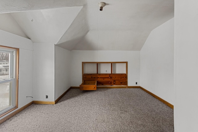 additional living space featuring carpet, vaulted ceiling, and a wealth of natural light