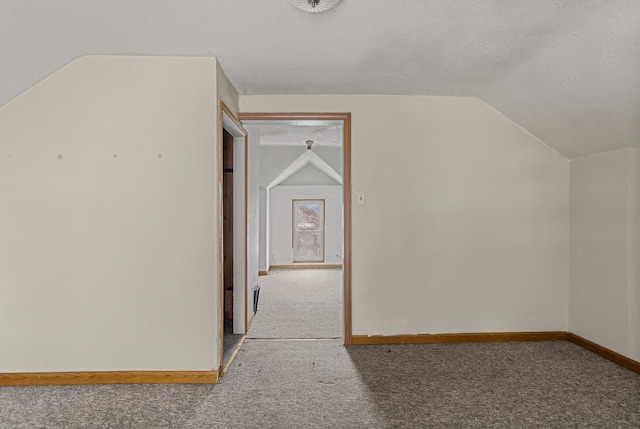 bonus room featuring a textured ceiling, carpet floors, and vaulted ceiling