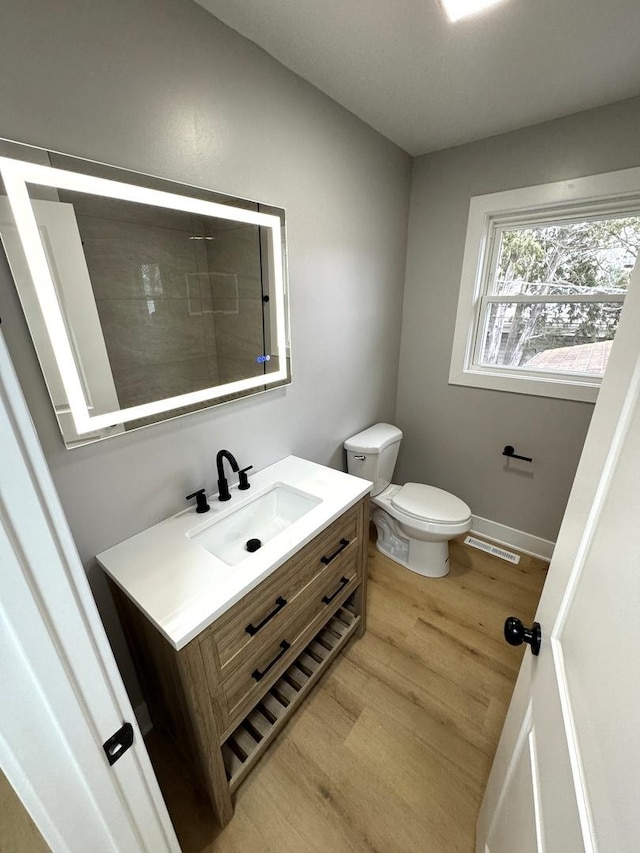 bathroom featuring toilet, vanity, and hardwood / wood-style flooring