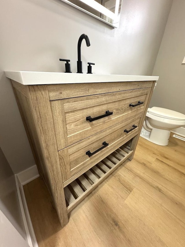 bathroom featuring sink, hardwood / wood-style floors, and toilet