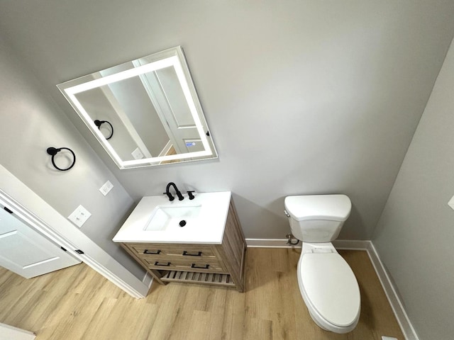 bathroom with hardwood / wood-style floors, vanity, and toilet