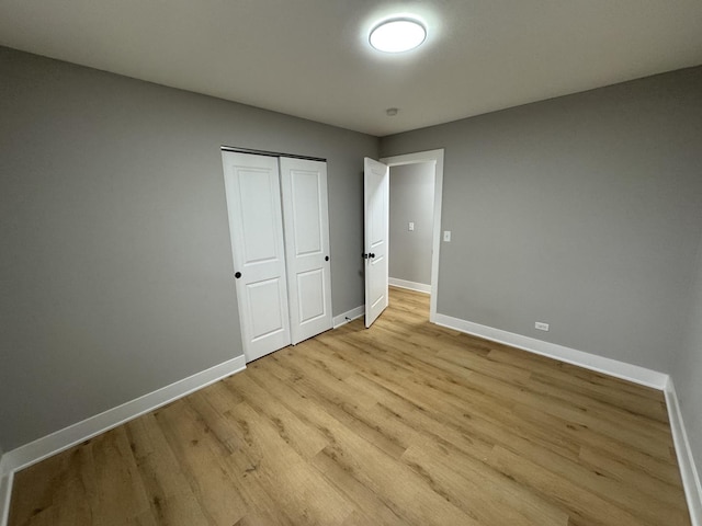 unfurnished bedroom with a closet and light hardwood / wood-style floors