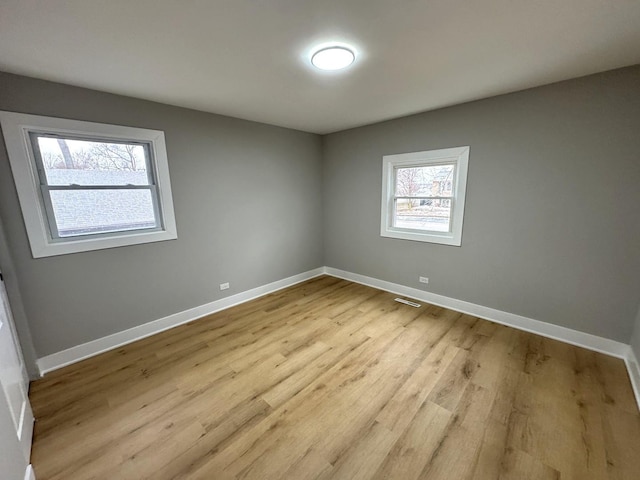 unfurnished room featuring plenty of natural light and light wood-type flooring