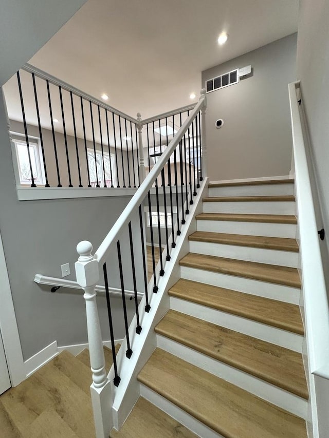 stairs featuring hardwood / wood-style floors