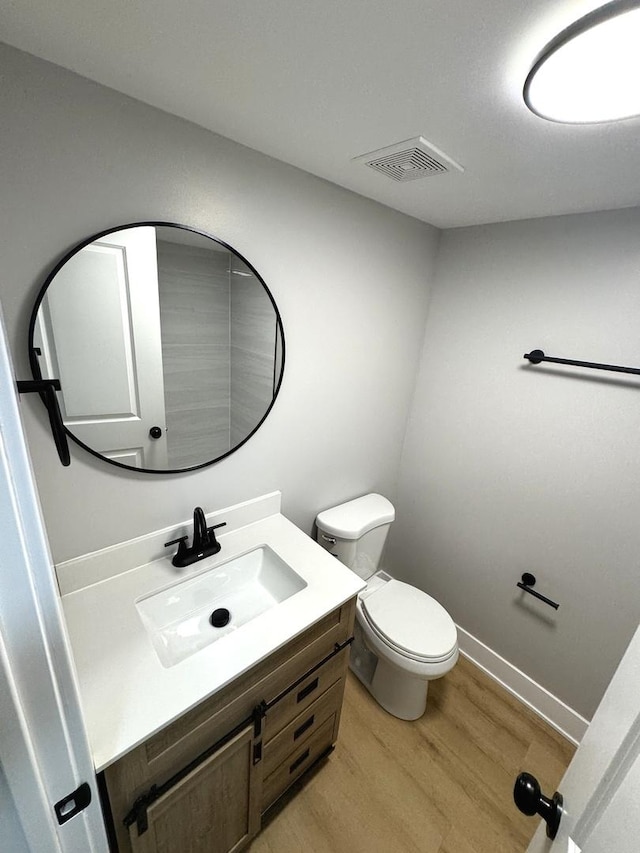 bathroom featuring hardwood / wood-style floors, vanity, and toilet