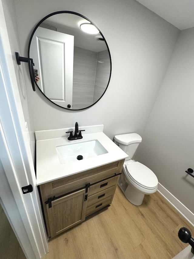 bathroom with vanity, toilet, and wood-type flooring