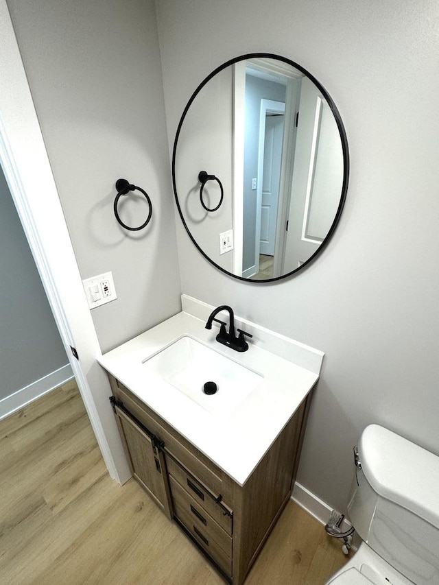 bathroom featuring hardwood / wood-style floors, vanity, and toilet