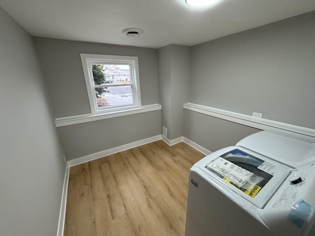 laundry area with independent washer and dryer and light hardwood / wood-style flooring