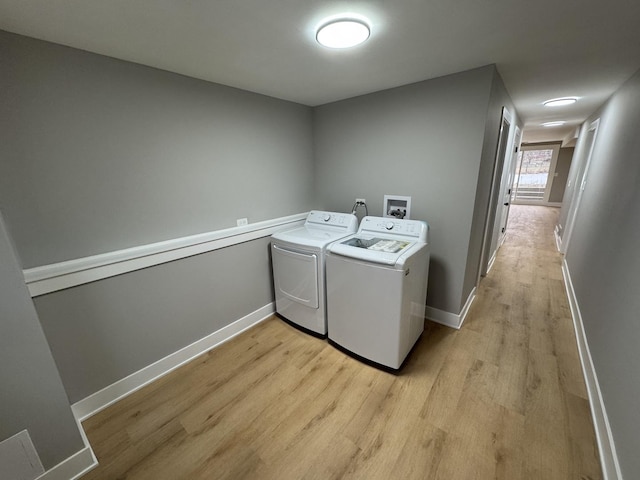 washroom with washing machine and dryer and light hardwood / wood-style floors