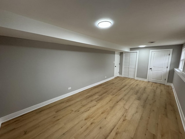 basement with light hardwood / wood-style flooring