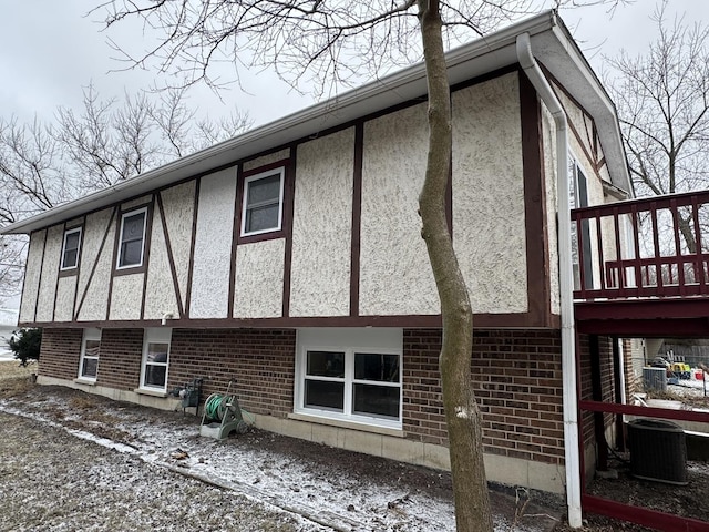 snow covered property featuring central air condition unit and a deck