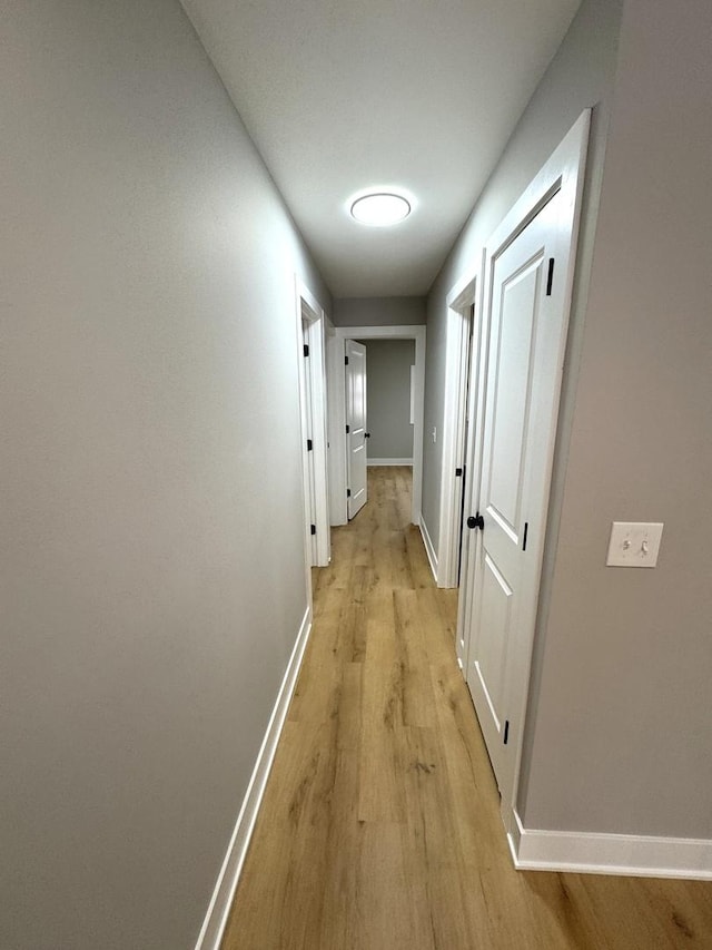 hallway with light hardwood / wood-style floors