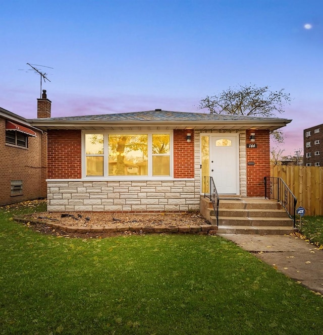 single story home featuring a lawn