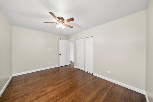 unfurnished bedroom featuring ceiling fan, a closet, and dark wood-type flooring