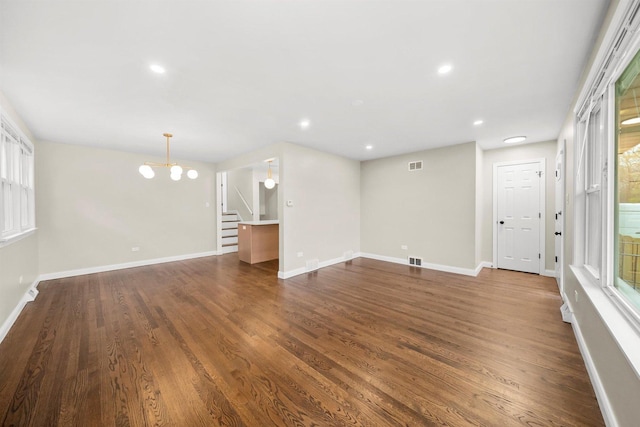 unfurnished living room featuring dark hardwood / wood-style floors and a chandelier