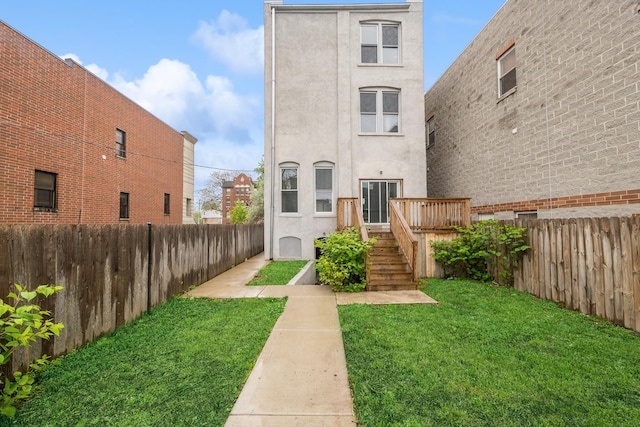 back of house featuring a yard and a wooden deck