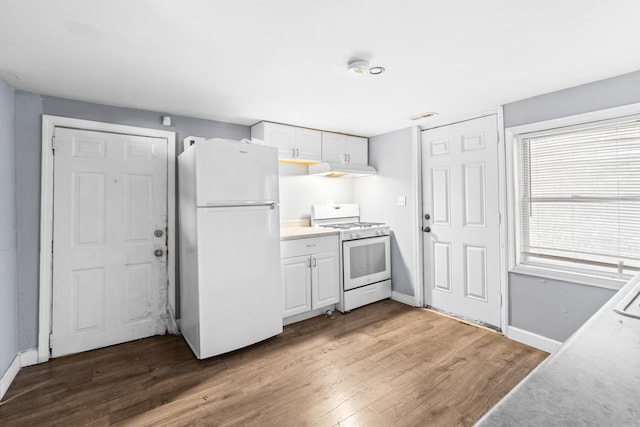 kitchen featuring hardwood / wood-style flooring, white cabinetry, white appliances, and range hood