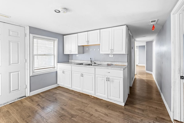 kitchen featuring dark hardwood / wood-style flooring, white cabinetry, and sink