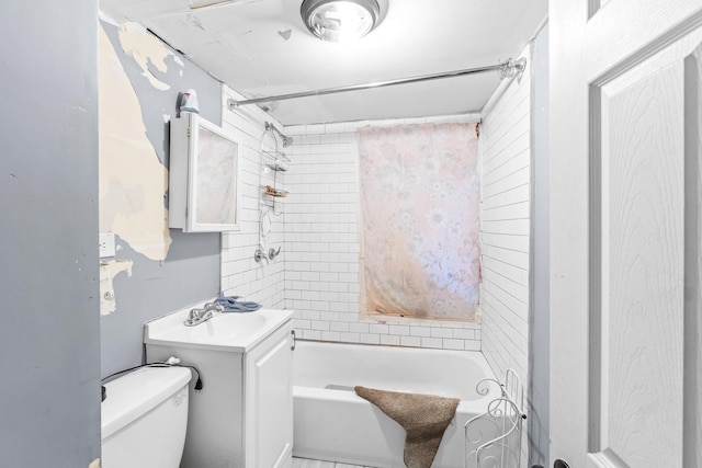 full bathroom featuring tiled shower / bath combo, toilet, and vanity