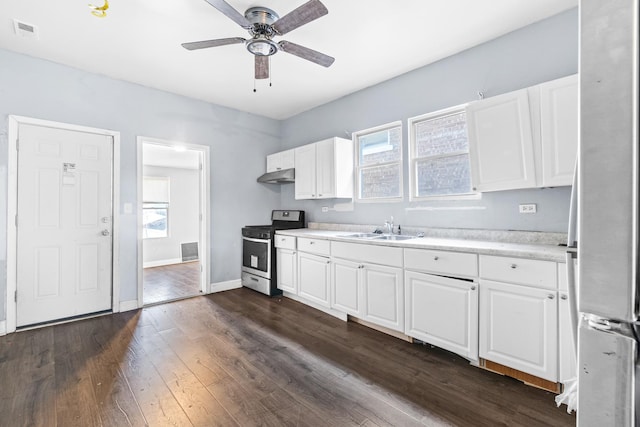 kitchen with white cabinets, a wealth of natural light, sink, and stainless steel stove