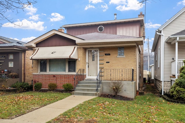 view of front of property with central AC and a front lawn