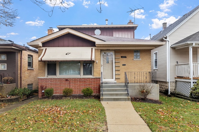 bungalow-style home with a front yard