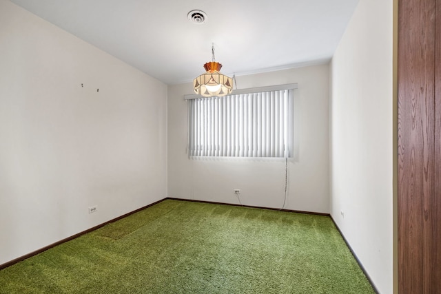 carpeted empty room featuring a notable chandelier