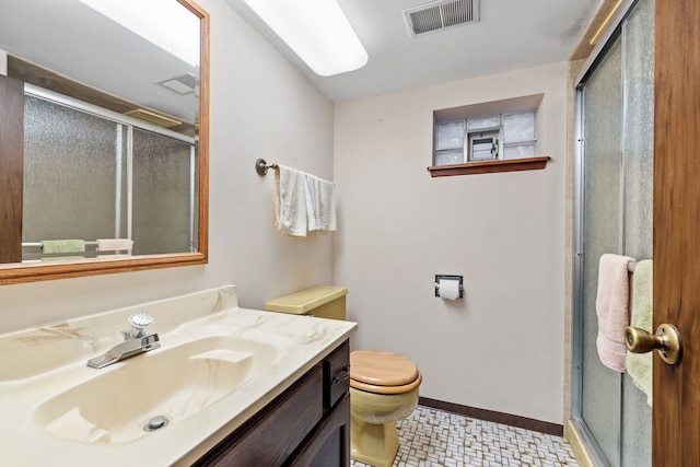 bathroom featuring a shower with door, vanity, and toilet