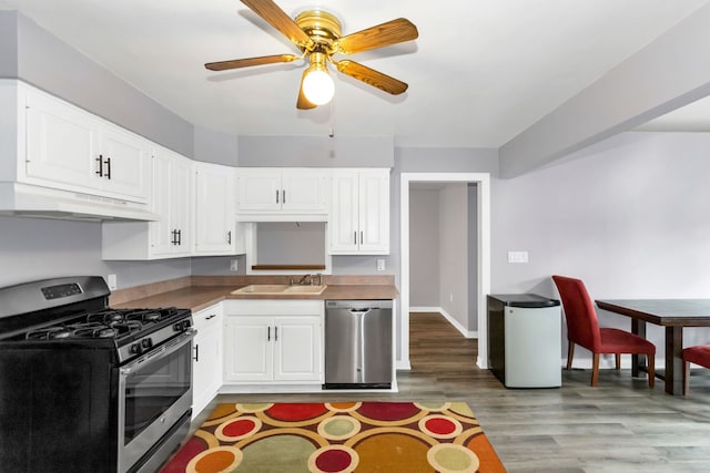 kitchen featuring white cabinets, sink, light hardwood / wood-style flooring, ceiling fan, and stainless steel appliances