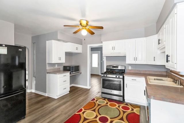 kitchen with ceiling fan, sink, dark wood-type flooring, stainless steel appliances, and white cabinets