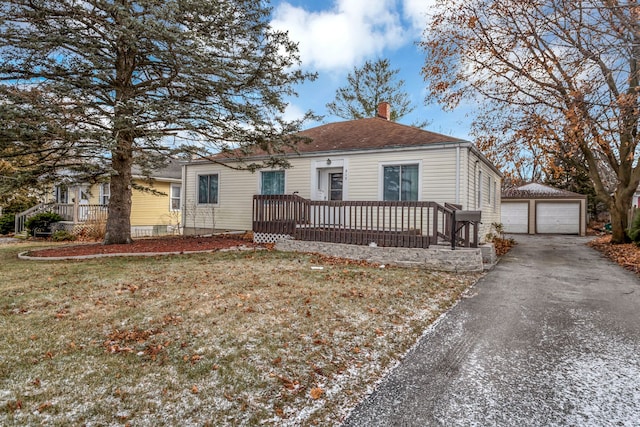 view of front of house featuring an outbuilding, a garage, and a front lawn