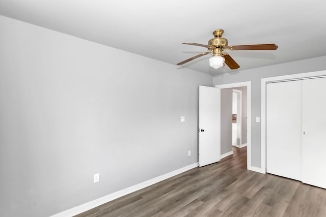 unfurnished bedroom with ceiling fan, a closet, and dark wood-type flooring