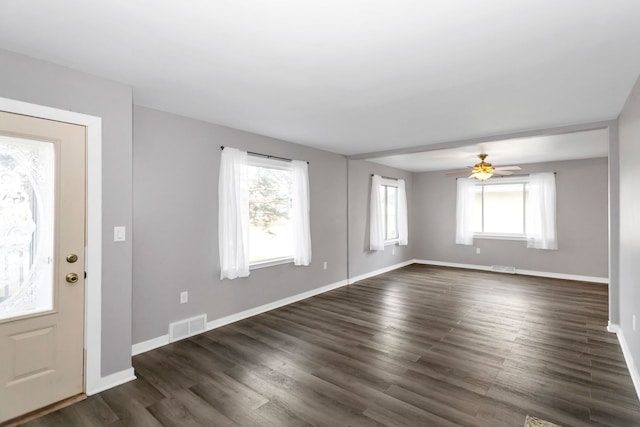 foyer entrance featuring ceiling fan, a healthy amount of sunlight, and dark hardwood / wood-style flooring