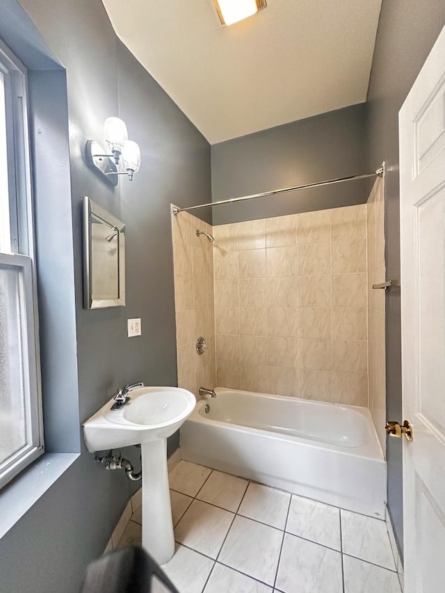 bathroom with tile patterned flooring, tiled shower / bath combo, and a wealth of natural light