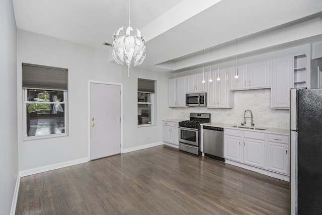 kitchen with white cabinetry, sink, stainless steel appliances, and an inviting chandelier