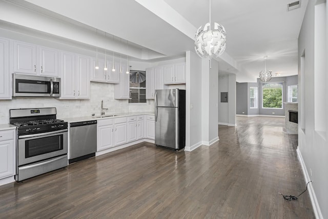 kitchen featuring a chandelier, white cabinetry, stainless steel appliances, and decorative light fixtures