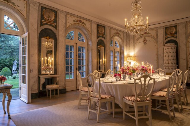 dining room with hardwood / wood-style flooring, an inviting chandelier, and french doors