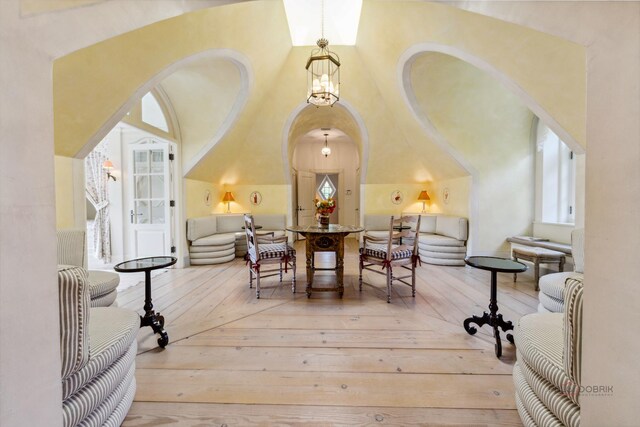 dining room with wood-type flooring and a towering ceiling