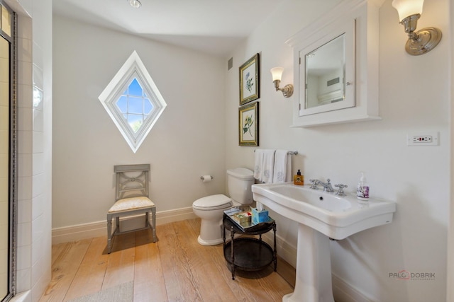 bathroom with hardwood / wood-style floors and toilet