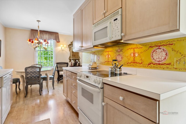 kitchen featuring white appliances, a notable chandelier, light brown cabinetry, decorative light fixtures, and light wood-type flooring