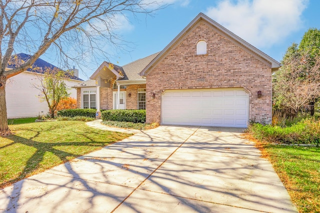 view of property featuring a garage and a front lawn