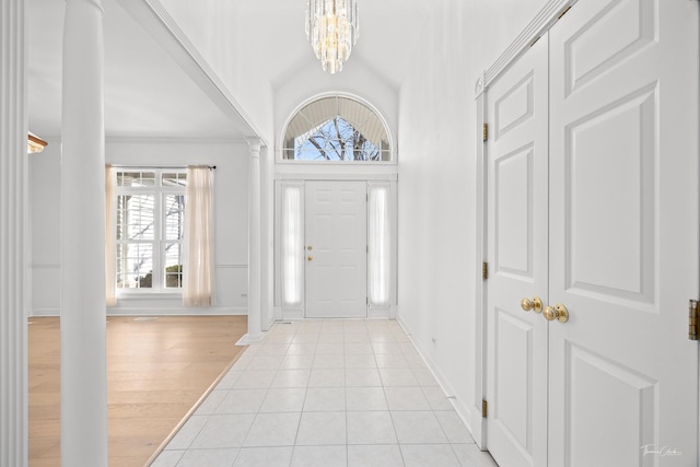 entryway with vaulted ceiling, a chandelier, and light hardwood / wood-style floors