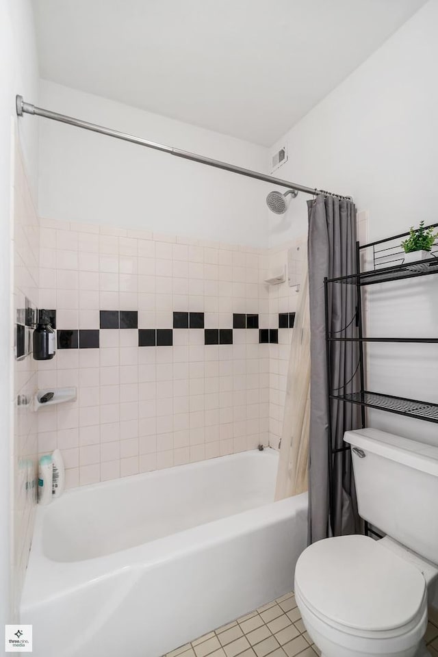 bathroom featuring shower / bath combo with shower curtain, tile patterned flooring, and toilet