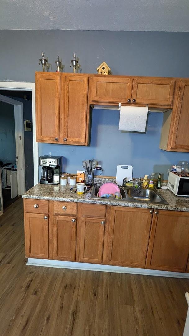 kitchen with a textured ceiling, dark hardwood / wood-style floors, and sink