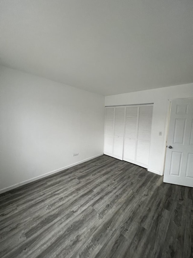 unfurnished bedroom featuring dark hardwood / wood-style floors and a closet