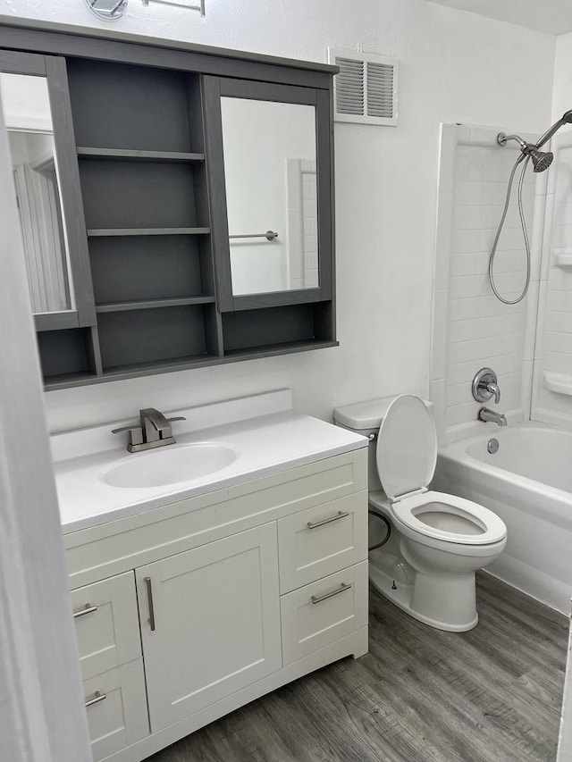 full bathroom with hardwood / wood-style flooring, vanity, shower / bath combination, and toilet