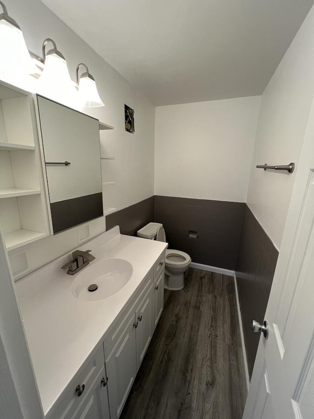 bathroom with vanity, toilet, and wood-type flooring