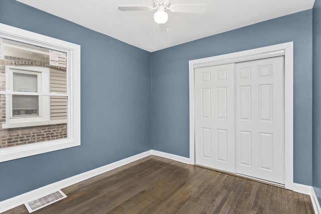 unfurnished bedroom with a closet, ceiling fan, and dark hardwood / wood-style floors